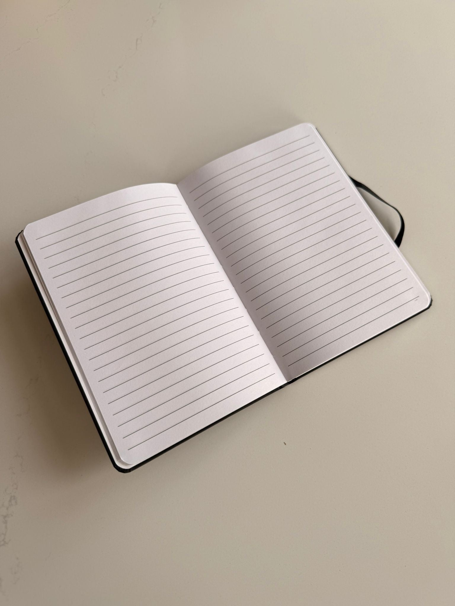 Open notebook with lined pages on a beige background
