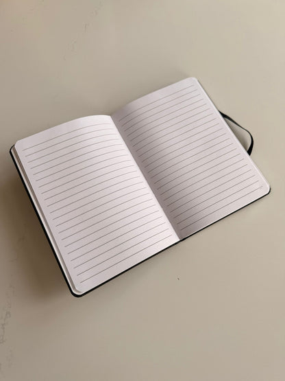 Open notebook with lined pages on a beige background